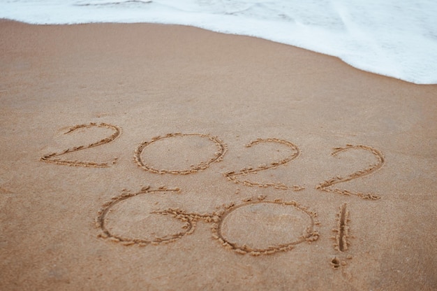 Commencez et allez 2022 sur le sable à la plage pour montrer la vie à venir l'année prochaine fond copyspace