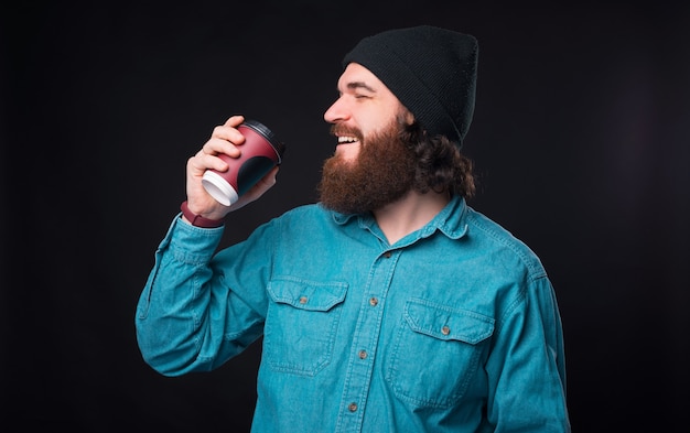 Commencez la journée avec une tasse de café, homme hipster barbu appréciant avec son cappuccino du matin