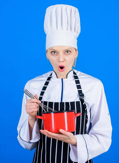 Commencez lentement à fouetter ou à battre la crème Utilisez un fouet à main Concept d'ustensiles de cuisine Meilleures techniques de fouettage Une femme chef tient un fouet et une marmite Fouetter comme un professionnel Fille fouetter des œufs ou de la crème