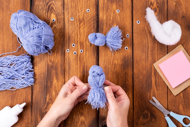 Comment faire un joli oiseau en fil pour la décoration. Projet artistique pour enfants. Notion de bricolage. Les mains sont faites de fils bleus d'une colombe bleue. Instructions photo étape par étape.