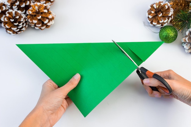 Comment faire un sapin de Noël créatif à partir de papier de couleur et de colle de vos propres mains. Notion de bricolage. Instructions pas à pas.