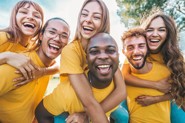 Communauté multiraciale de jeunes souriant à la caméra à l'extérieur