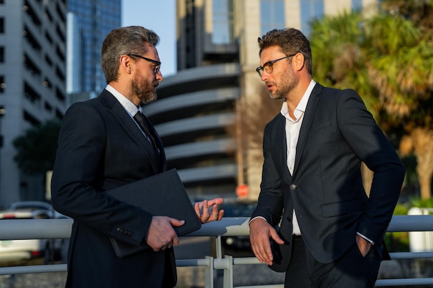 Communication d'affaires deux hommes d'affaires parler à l'extérieur deux hommes d'affaires divers parler ensemble co