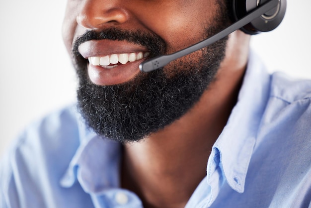 Photo communication en ligne homme noir avec casque et sourire à son bureau dans un bureau de travail moderne télémarketing ou support de consultant ou service client et agent de centre d'appels masculin au poste de travail