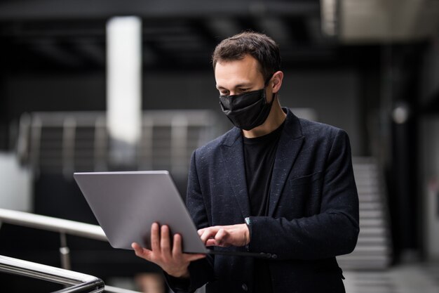 Communication de quarantaine. Homme d'affaires en masque médical travaillant sur ordinateur portable au bureau. Coronavirus. Covid19. Rester à la maison