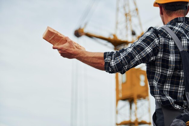 Communique avec le grutier Travailleur de la construction en uniforme et équipement de sécurité a un travail sur la construction