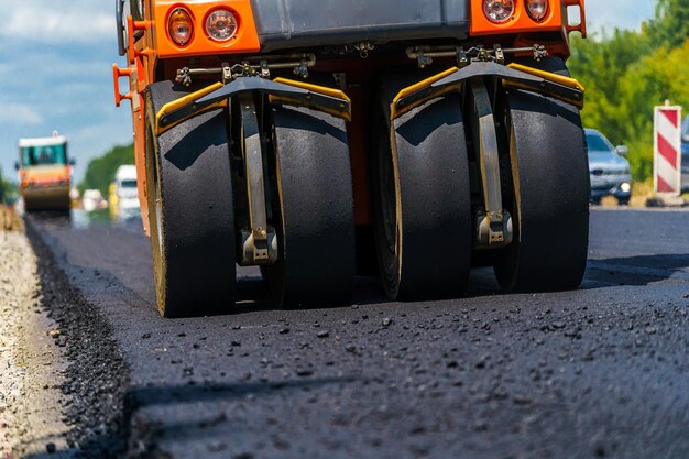 Le compacteur de réparation de route pose l'asphalte Machines spéciales lourdes Finisseur d'asphalte en fonctionnement Vue latérale Gros plan