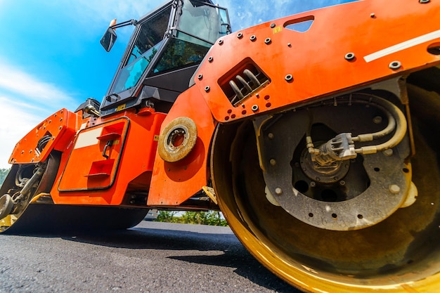Le compacteur de réparation de route pose l'asphalte Machines spéciales lourdes Finisseur d'asphalte en fonctionnement Vue latérale Gros plan