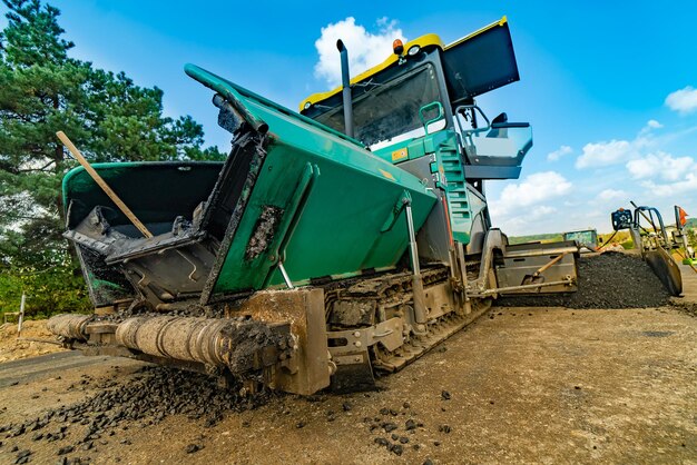 Le compacteur de réparation de route pose l'asphalte Machines spéciales lourdes Finisseur d'asphalte en fonctionnement Vue latérale Gros plan