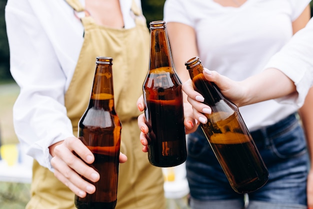 Une compagnie d'amis élevant une bouteille - Gros plan des mains