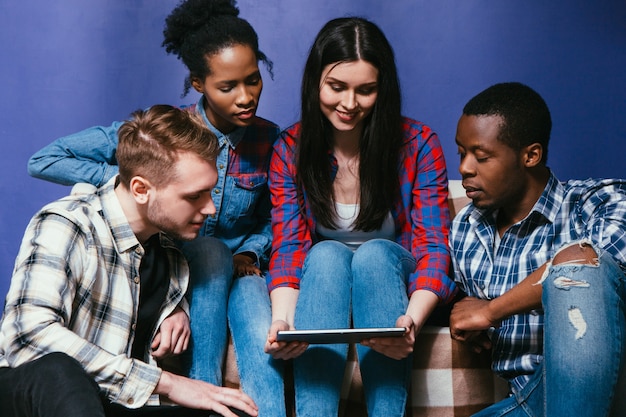 Photo une compagnie de jeunes amis interracial s'amuse avec une tablette