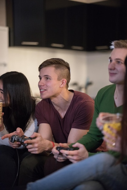 Compagnie de jeunes amis passant du temps ensemble deux jeunes hommes jouant à des jeux