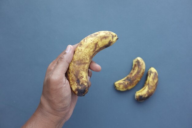 Comparaison d'une banane pourrie avec une banane mûre sur fond blanc