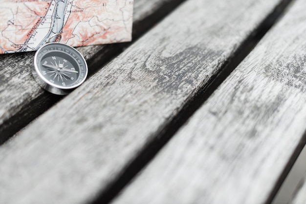 Photo compas et carte sur une belle surface en bois. vue de dessus