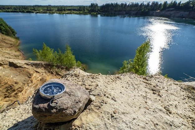 Le compas magnétique repose sur une pierre au bord du réservoir