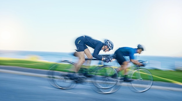 Compétition de flou de mouvement et cycliste à vélo sur route dans la nature avec casque exercice aventure et vitesse Défi de course cycliste et hommes avec vélo pour une motivation ou de l'énergie d'entraînement rapide
