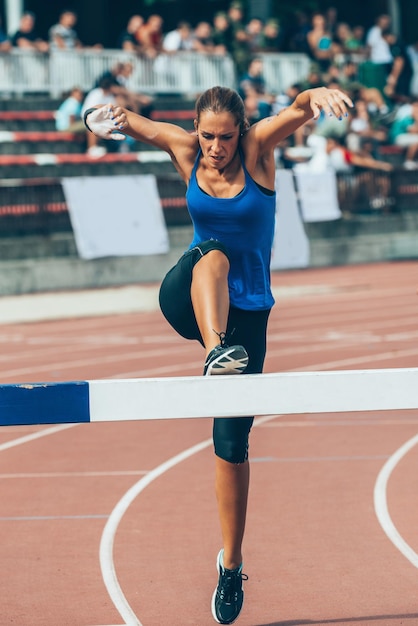 Une compétitrice traversant l'obstacle du steeplechase