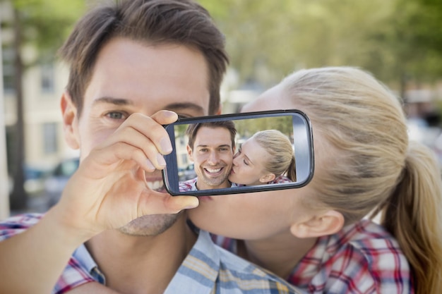 Composite de couple prenant selfie sur smartphone