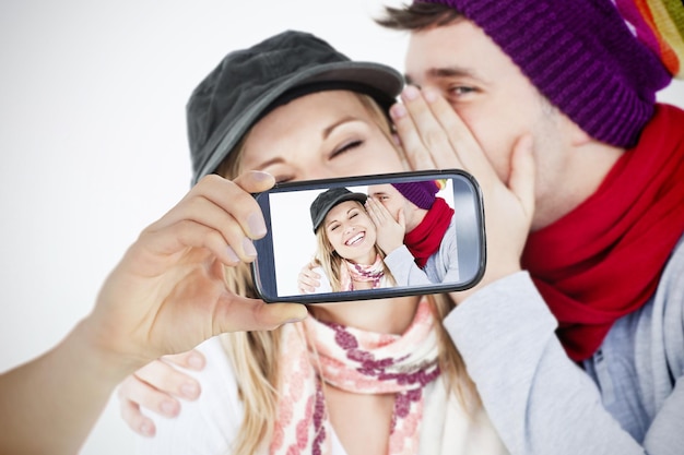 Composite de couple prenant selfie sur smartphone