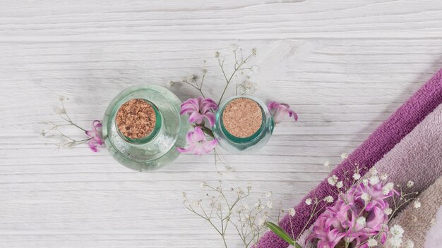 Composition abstraite de serviettes de fleurs de jacinthes roses et de bouteilles de cosmétiques bio à l'huile essentielle