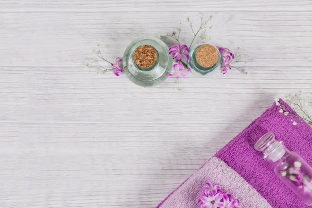 Composition abstraite de serviettes de fleurs de jacinthes roses et de bouteilles de cosmétiques bio à l'huile essentielle