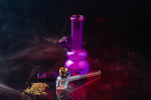 Composition D'accessoires Pour Fumeurs Avec Pipe Et Tas De Mauvaises Herbes Bang En Verre Violet Nature Morte