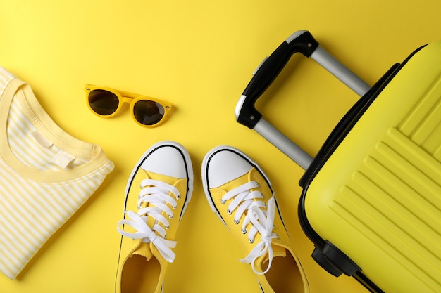 Composition avec accessoires de voyage sur fond jaune