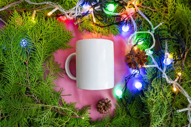 La composition affiche le produit. mug blanc sur vieux bois rond à décor de feuilles de sapin. idées d'affichage de produits d'été