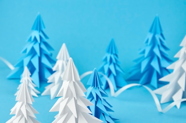 Composition d'arbres de noël en origami en papier blanc et bleu