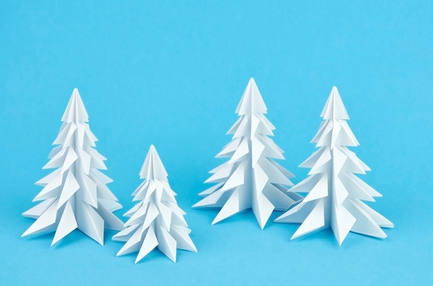Composition d'arbres de Noël origami papier blanc sur bleu
