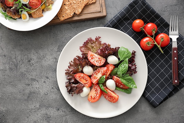 Composition avec assiette de salade et tomates cerises fraîches sur serviette à carreaux