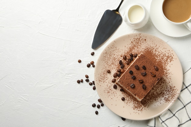 Composition avec assiette de tiramisu savoureux sur blanc.