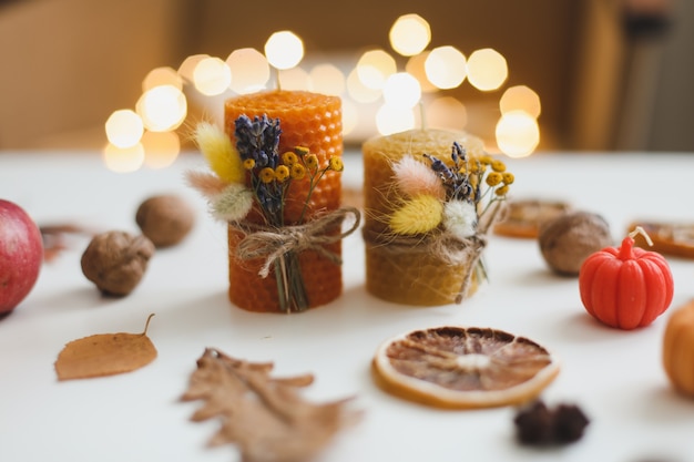 Composition d'automne confortable avec des bougies et des feuilles de cire de citrouille