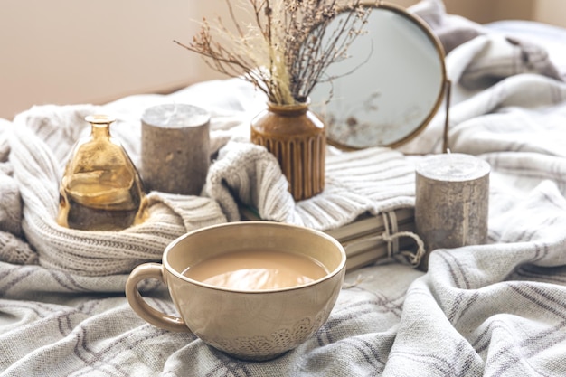 Composition d'automne confortable avec une tasse de café et des bougies au lit
