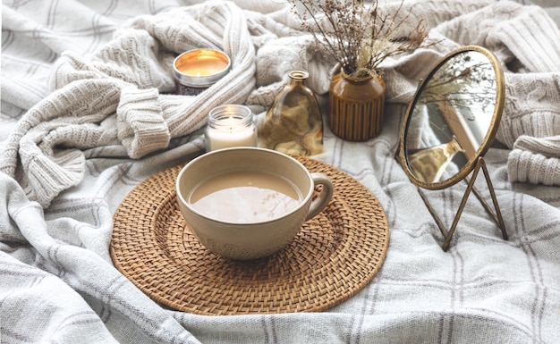 Composition d'automne confortable avec une tasse de café et des bougies au lit