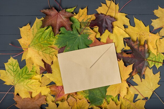 Composition d'automne L'enveloppe repose sur des feuilles jaunes Modèle Toile de fond Maquette