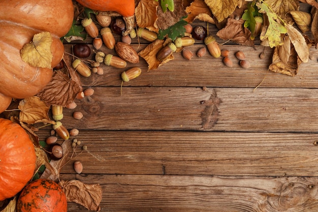 Photo composition d'automne avec des feuilles sèches et des citrouilles mûres sur une table en bois vue de dessus espace de copie