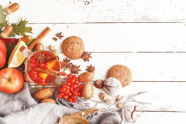 Photo composition d'automne d'une tasse de thé chauffant feuilles d'automne fruits et épices sur une table en bois blanc vue de dessus espace de copie