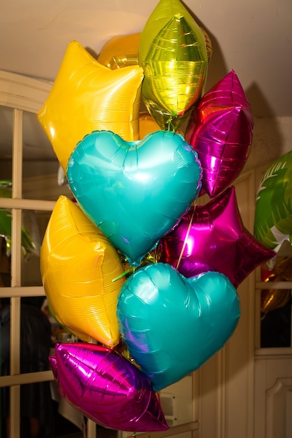 Composition de ballons bleus, or, orange et roses à l'hélium. Ballon aluminium en forme d'étoile. Le concept de décorer une pièce avec des ballons à l'hélium pour les vacances ou les anniversaires