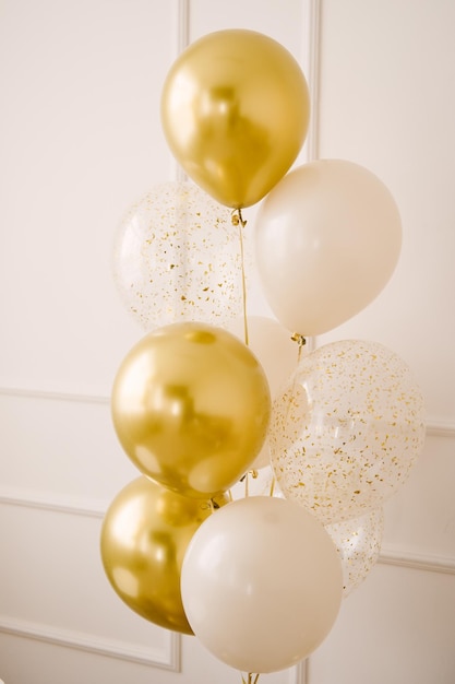 Photo composition de ballons à l'hélium blancs transparents avec des confettis ainsi qu'une grande figure d'une couleur dorée cadeau pour 1 ans