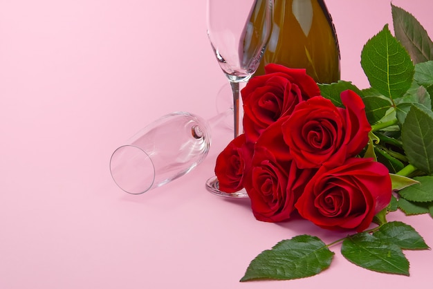 Une composition d'un beau bouquet de roses, de bougies, de verres et d'une bouteille de champagne crée une carte romantique. Le concept de la Saint-Valentin, fête des mères, 8 mars.