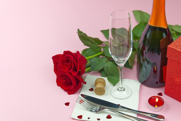 Une composition d'un beau bouquet de roses, de verres et d'une bouteille de champagne crée une carte ou une affiche romantique. Le concept de la Saint-Valentin, fête des mères, 8 mars.