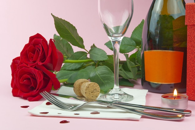 Une composition d'un beau bouquet de roses, de verres et d'une bouteille de champagne crée une carte ou une affiche romantique. Le concept de la Saint-Valentin, fête des mères, 8 mars.