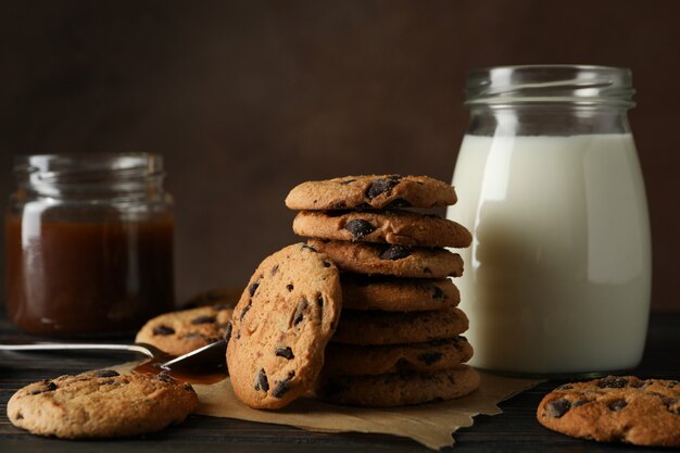 Composition avec biscuits aux brisures, lait et caramel sur table en bois