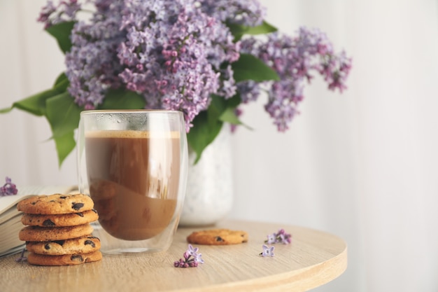 Composition avec biscuits aux pépites de chocolat, cacao et lilas sur table en bois