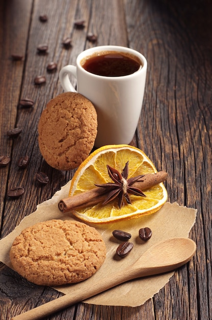 Composition de biscuits à l'avoine et d'une tasse à café sur une table en bois foncé