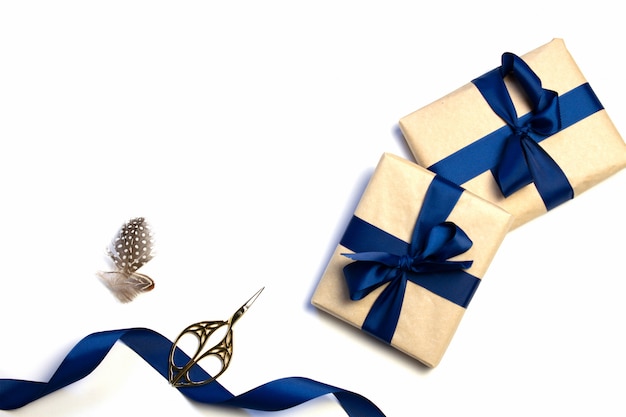 Une composition de cadeaux emballés, de papier Kraft et de ruban bleu isolé sur fond blanc. La vue d'en haut. Pour maquette, invitation.