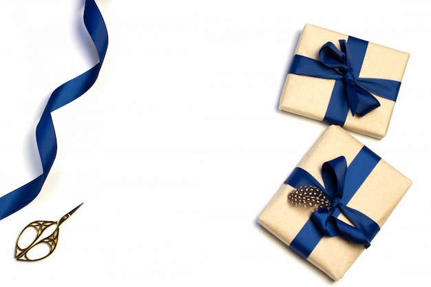 Une composition de cadeaux emballés, de papier Kraft et de ruban bleu isolé sur fond blanc. La vue d'en haut. Pour maquette, invitation.