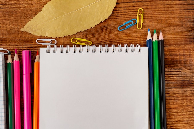 Composition avec cahier coloré de page blanche de cahier, marqueur et maquette de stylo Retour au concept de l'école