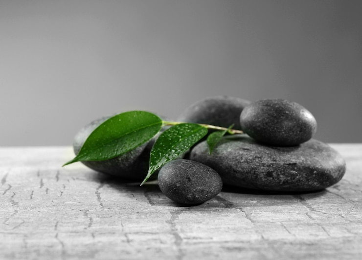 Photo composition de cailloux avec des feuilles sur la table sur un fond gris
